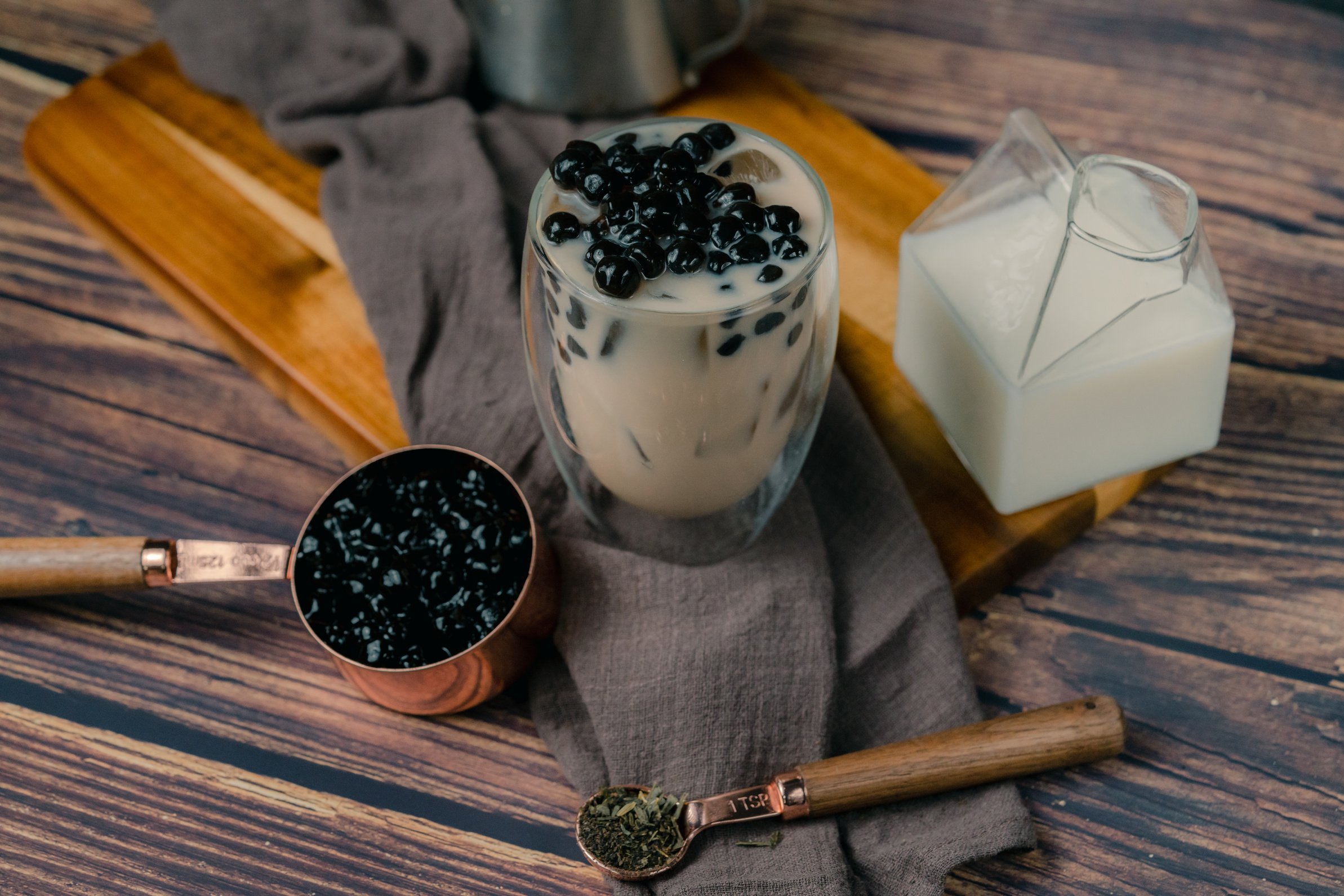 Glass of Milk Tea on Wooden Board with Tablecloth