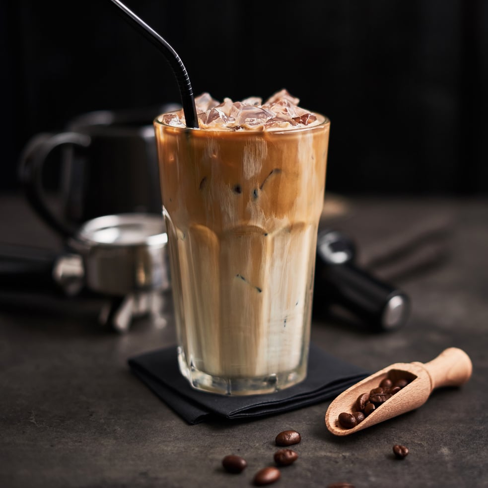 Ice coffee with cream in a tall glass with straw